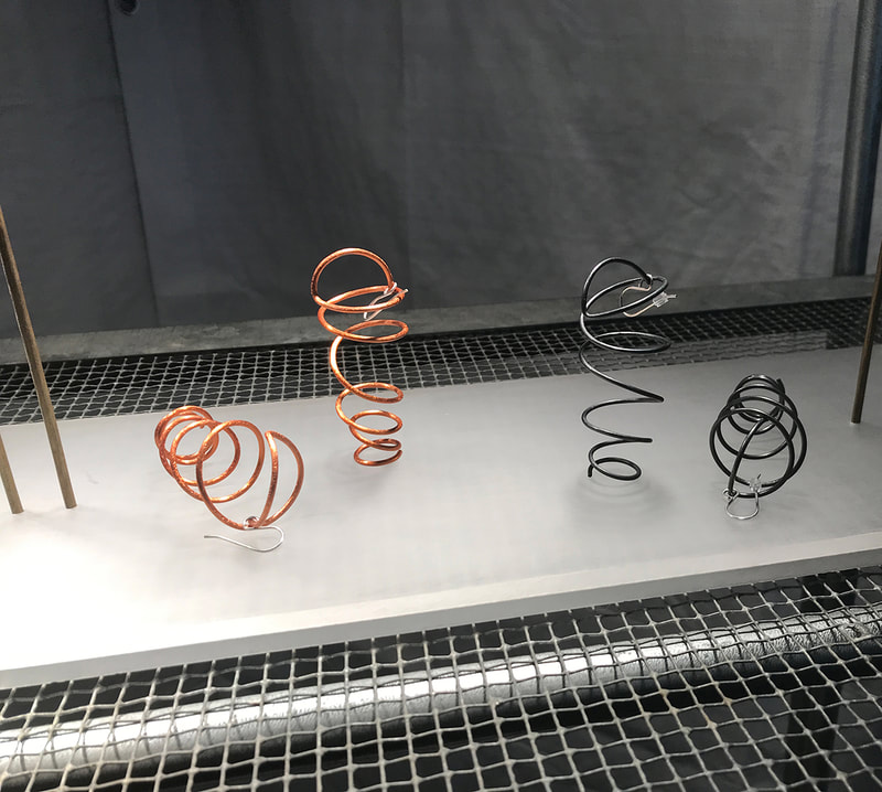 Swinging Coil Earrings on display