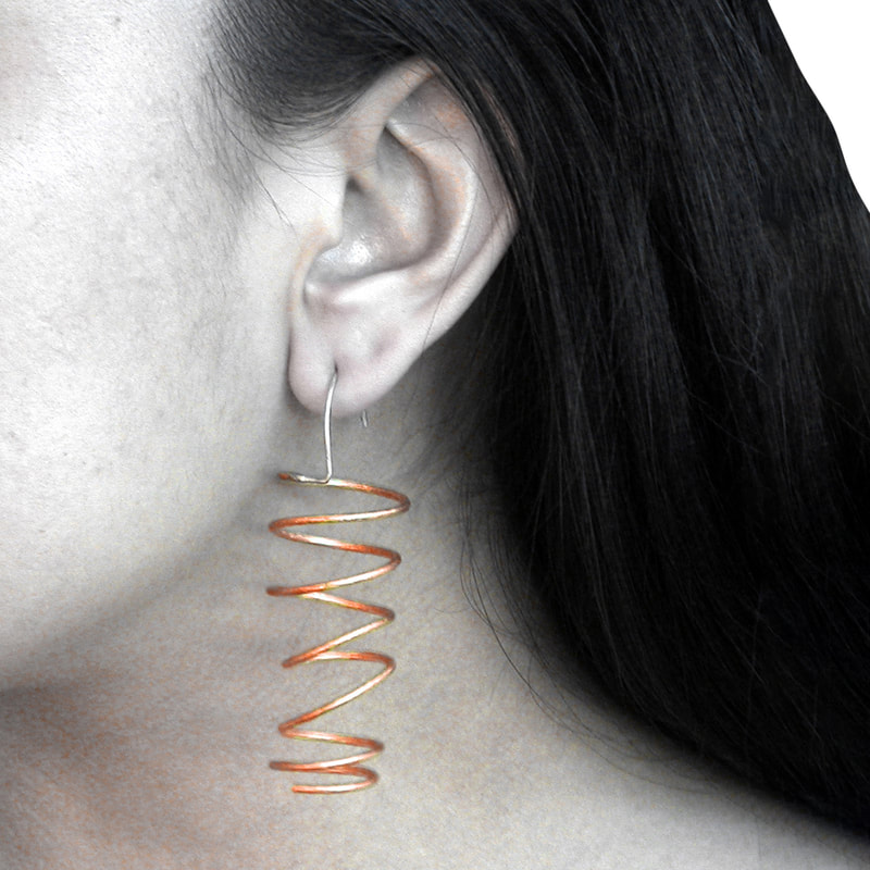 Dangling Coil Earrings in copper on model